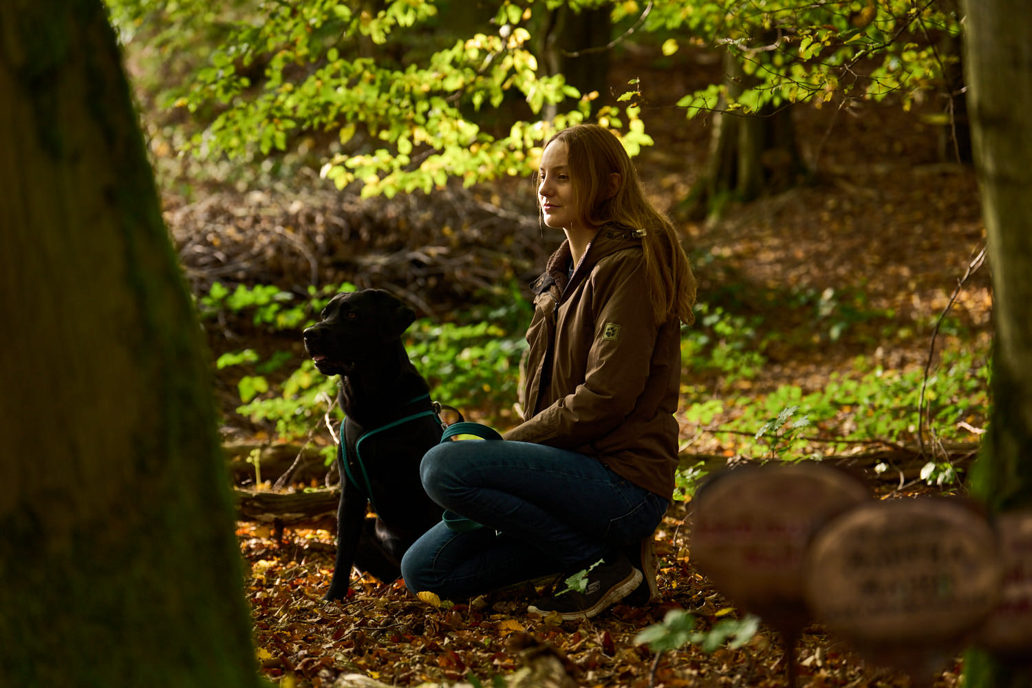 Frau mit Hund an einem Baumgrab im TrauerPark Eremia