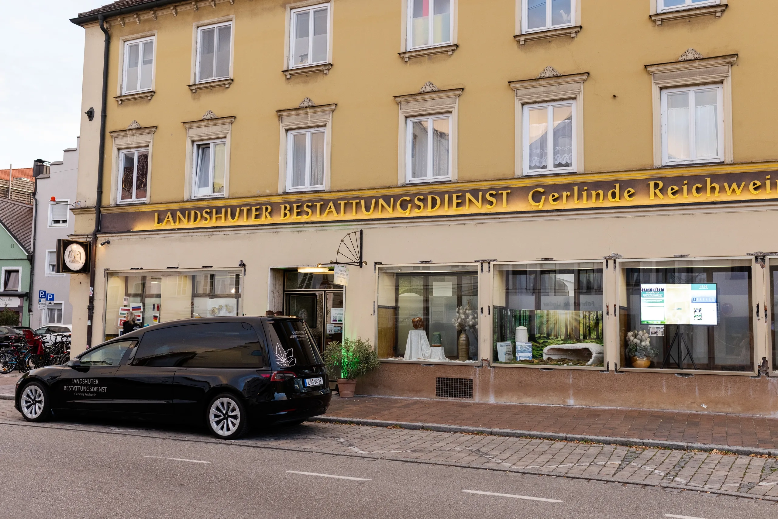 Elektrischer Bestattungswagen (Tesla Model 3) vor dem Hauptstandort des Landshuter Bestattungsdiensts am Bismarckplatz in Landshut