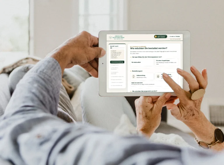 Ein Paar plant auf dem Sofa mit dem Tablet die Bestattungsvorsorge im Online-Vorsorgeplaner des Landshuter Bestattungsdiensts